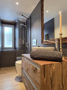 y baño con encimera de madera, bañera y lavamanos. en Casa Bolivia, en Grächen