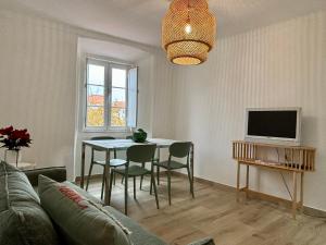 a living room with a table and a tv at A Casa da Praça in Vila Viçosa