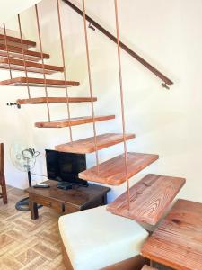 a living room with wooden stairs and wooden tables at Ventana al Mar in Playa Hermosa +17 photos