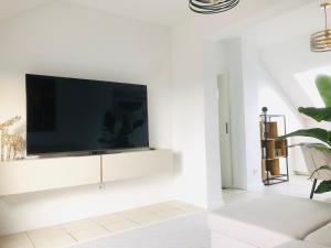 a living room with a flat screen tv on a white wall at Dom 007 in Fulda