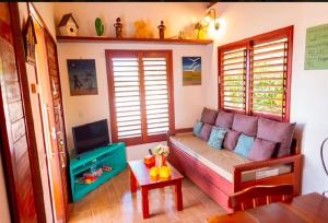a living room with a couch and a table at Vila Feliz - Chalés completos - ideal para famílias in Serra de São Bento