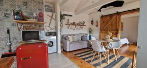 a living room with a red refrigerator and a table at Casa Mar do Triângulo in Horta