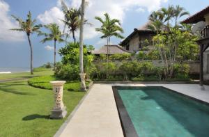 a villa with a swimming pool and a house at Villa Nirwana in Tanah Lot