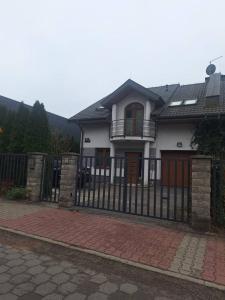 a white house with a black fence at Villa Varzob in Warsaw