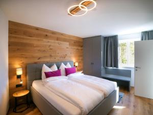 a bedroom with a large bed with pink pillows at ALPENGONDEL Suite - Charming Mountain Apartment with Balcony, presented by AlpenLuxus in Kramsach