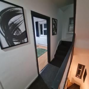 a hallway with a mirror and a stair case at Colebert Avenue in London