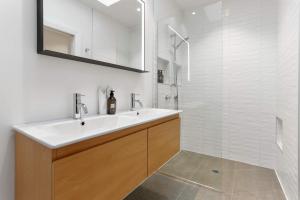 a white bathroom with a sink and a shower at Luxury Central Villa with Spa Pool Prime Location in Auckland +27 photos