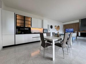 a dining room with a white table and chairs at Casa Agnese Lake View in Brenzone sul Garda