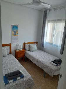 a bedroom with two beds and a window at Lemon Apartment - Aquamarina Cabo Roig in Playas de Orihuela