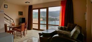 a living room with a couch and a large window at VIP Complex in Sarnitsa
