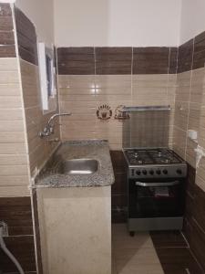 a small kitchen with a sink and a stove at Hmmam in Quseir