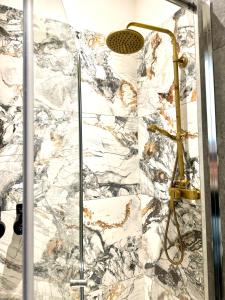 a shower in a bathroom with a marble wall at Belvedere Apartment in Vienna +21 photos