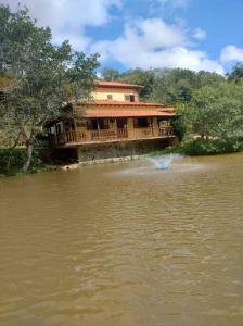 a building on a river with a house on it at Casa à Beira da Lagoa,Tiradentes in Tiradentes