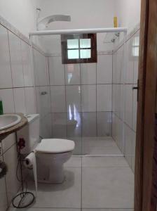 a white bathroom with a toilet and a sink at Casa à Beira da Lagoa,Tiradentes in Tiradentes
