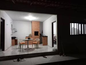 a room with a table and chairs and a kitchen at Simplesmente aconchegante in Itapoa +4 photos