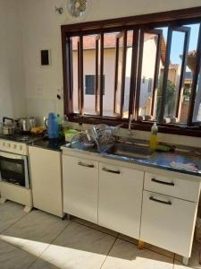 a kitchen with a sink and a stove at Simplesmente aconchegante in Itapoa