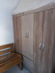 a wooden cabinet and a wooden bench in a room at Simplesmente aconchegante in Itapoa
