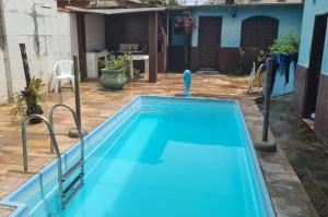 a large blue swimming pool in a yard at Linda Saquarema in Saquarema