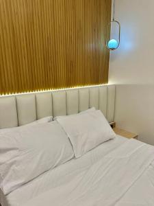 a bed with white sheets and a light above it at Valencia Cozy Suites in Valencia