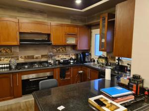 a kitchen with wooden cabinets and a black counter top at 2 spacious bedrooms apartment in Cairo +9 photos