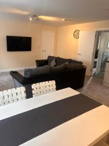 a living room with a couch and a tv at Brand new apartments with Open plan kitchens & Diner , FREE WIFI & NETFLIX included in Burton upon Trent