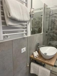 a bathroom with a sink and a mirror and towels at Cavour16 rent bedrooms in Genova