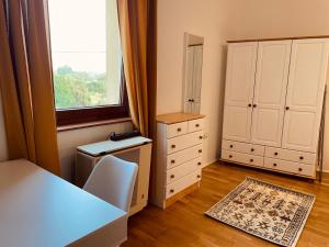 a bedroom with a bed and a dresser and a window at Zsolnay Walk-Up in Pécs