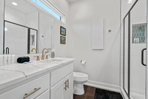 a white bathroom with two sinks and a toilet at The Betty, on 2 acres Hot tub & 2 King Beds in Hot Springs +28 photos