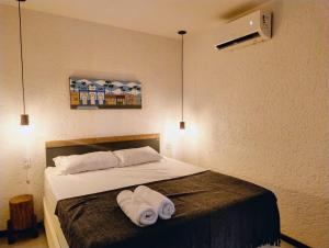 a bedroom with a bed with two towels on it at Patacho Porto Gamboa in Pôrto de Pedras +23 photos