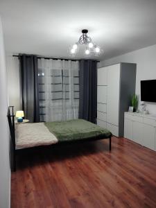 a bedroom with a bed and a chandelier at Apartament Julia in Zamość