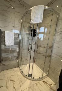 CanveyにあるDeluxe 4 Bedroom House With Free Parkingの浴室のガラス扉付きシャワー