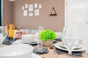 a dining room table with white plates and wine glasses at Enchanting 4 spacious bedrooms in Birmingham +81 photos