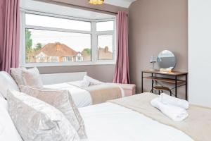 a bedroom with two beds and a window at Enchanting 4 spacious bedrooms in Birmingham