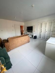 a living room with a couch and a flat screen tv at Casa Grande 400m da praia do lado do centrinho in Imbé +3 photos