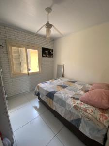 a bedroom with a bed and a window at Casa Grande 400m da praia do lado do centrinho in Imbé