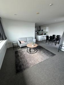 a living room with a couch and a table at Corporate Accommodation - Modern CBD Apartment in Hamilton