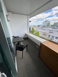 a balcony with a desk and a table and a window at Corporate Accommodation - Modern CBD Apartment in Hamilton