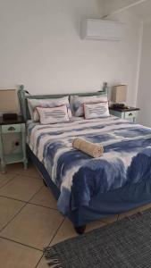 ジンクワジ・ビーチにあるSea Esta Coastal Beach Houseのベッド(青と白の掛け布団、枕付)