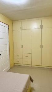 1 dormitorio con armarios blancos y 1 cama. en D and D Butuan Homestay, en Butuán 2 fotos más