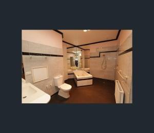 a bathroom with a toilet and a tub and a sink at Art House On The Park in Melbourne +48 photos