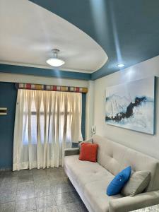 a living room with a white couch and a window at Flat em natal beira mar in Natal