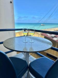 two glasses of white wine sitting on a table at Flat em natal beira mar in Natal