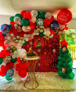 a red and green balloon arch with balloons and a table at Ecohotel La Casona Pereira in Pereira