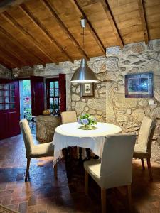 una sala da pranzo con tavolo, sedie e parete in pietra di Quinta da Boa Viagem a Viana do Castelo