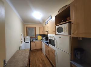 La cuisine est équipée d'un réfrigérateur blanc et d'un four micro-ondes. dans l'établissement BA Sports, à Font-Romeu