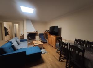 un salon avec un canapé bleu et une télévision dans l'établissement BA Sports, à Font-Romeu