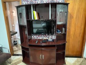 a wooden entertainment center with a tv in it at Edícula do Monte in Monte Carmelo