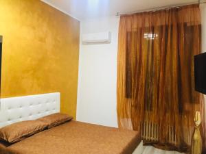 a bedroom with a bed and a window with curtains at Gold house in Ravenna