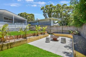 a backyard with a wooden fence and a garden at Margaret's Hamptons Beach House in Hawks Nest
