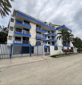 a large apartment building with blue balconies and a fence at Apartamento soberana del mar bello horizonte in Playa Bello Horizonte
